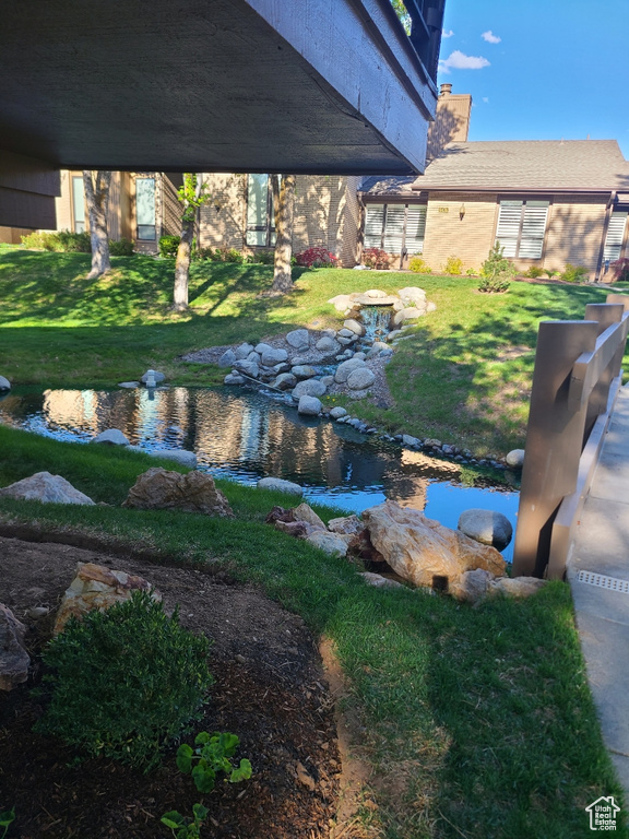 View of green lawn featuring a garden pond