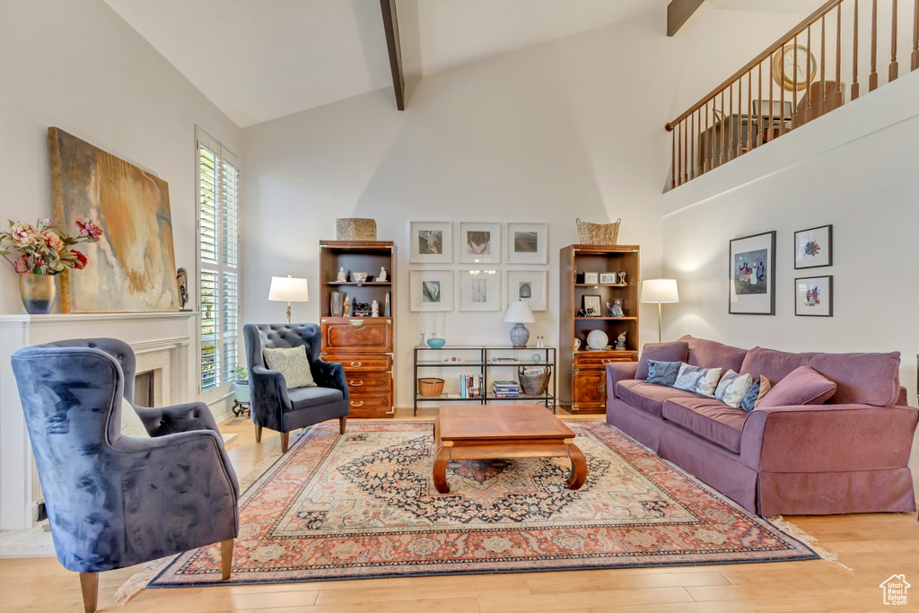 Living room featuring wood finished floors, beam ceiling, and high vaulted ceiling