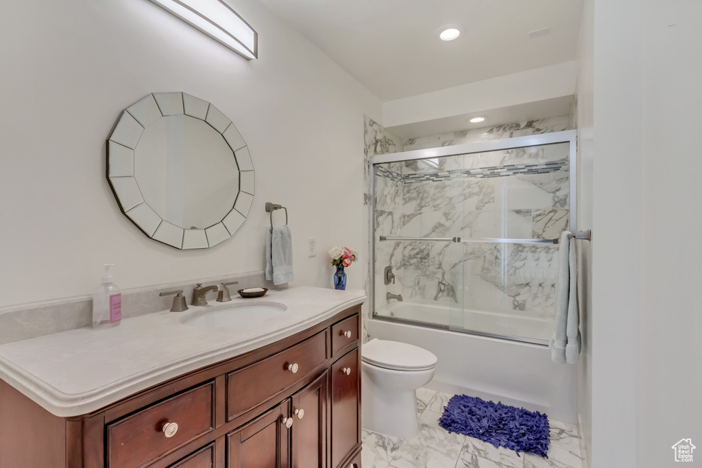 Full bathroom with recessed lighting, shower / bath combination with glass door, marble finish floor, toilet, and vanity