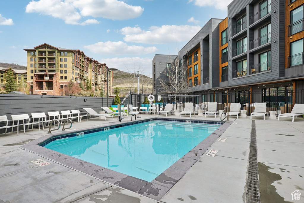 Pool featuring fence and a patio