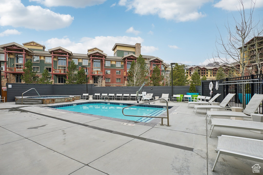 Pool with fence, a patio, and a hot tub