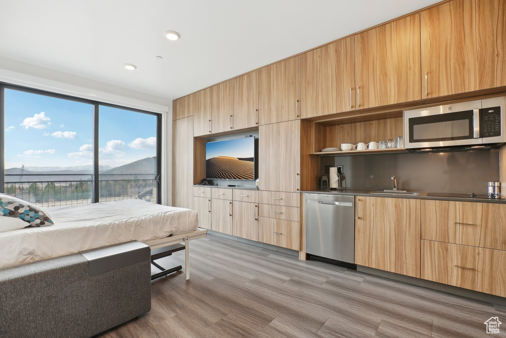 Living room with recessed lighting, wet bar, and light wood-type flooring