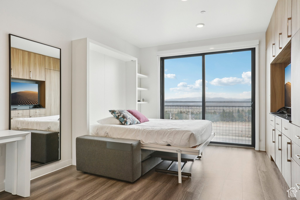 Bedroom with access to exterior and wood finished floors