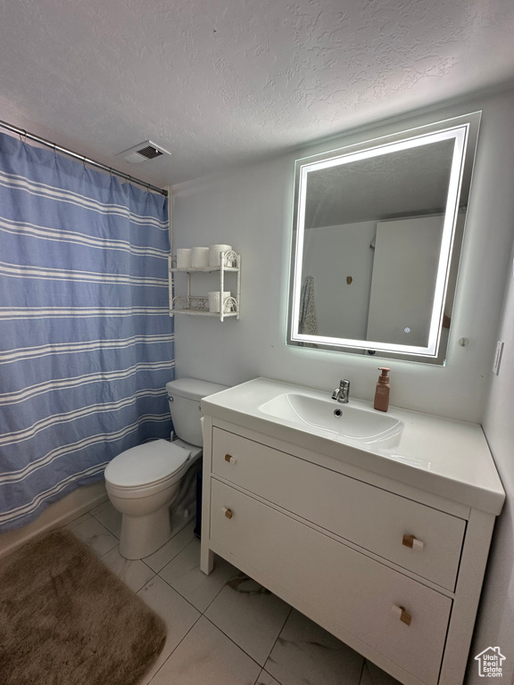 Bathroom featuring visible vents, toilet, vanity, a shower with shower curtain, and a textured ceiling