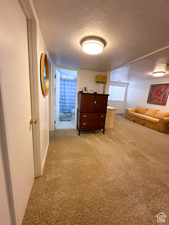 Corridor featuring carpet flooring and a textured ceiling
