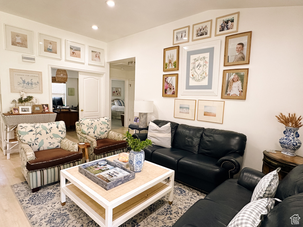 Living room with light wood finished floors and recessed lighting
