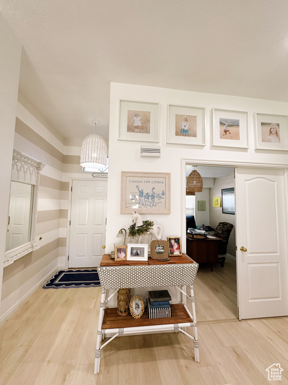 Foyer entrance with baseboards, a chandelier, and light wood-style floors