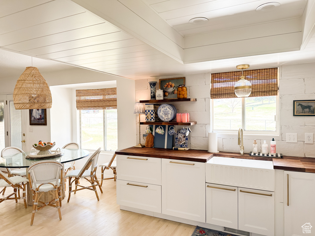 Kitchen with plenty of natural light, wood counters, a sink, and light wood-style flooring