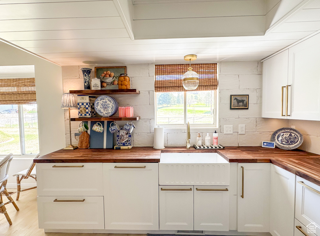 Kitchen with a wealth of natural light, a sink, and wooden counters