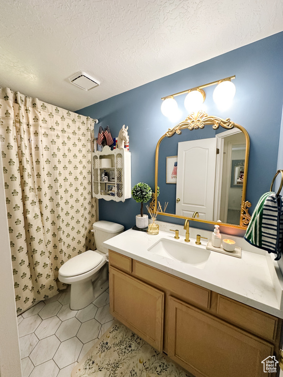 Full bathroom featuring a textured ceiling, toilet, visible vents, curtained shower, and vanity