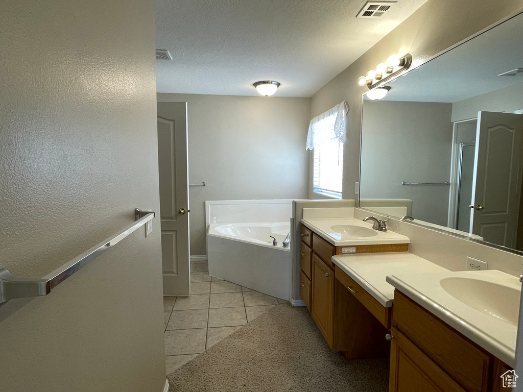 Full bath featuring a bath, visible vents, tile patterned floors, and vanity