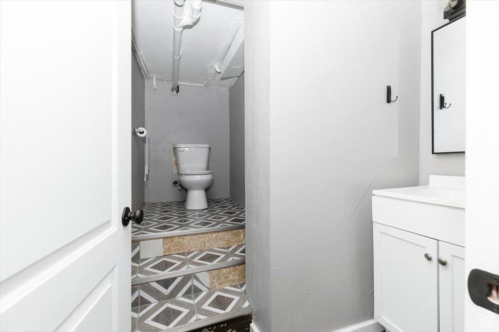 Half bathroom with vanity and toilet