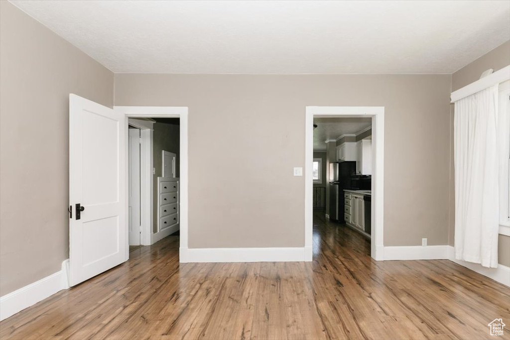 Interior space featuring baseboards, freestanding refrigerator, and light wood finished floors