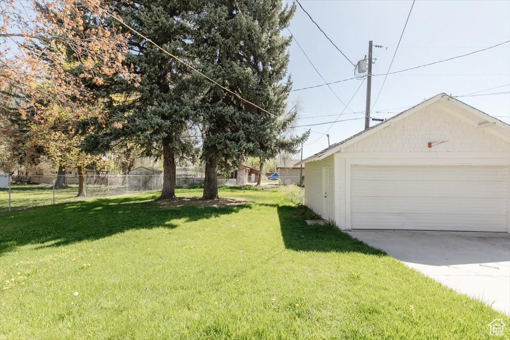 View of yard featuring a detached garage, fence, and an outdoor structure