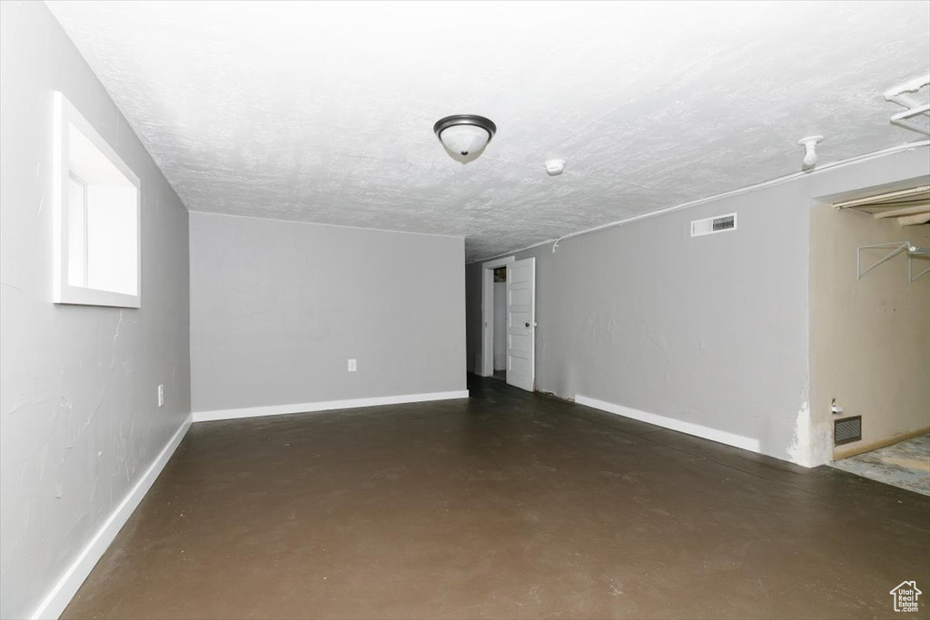Interior space featuring baseboards, visible vents, and finished concrete floors