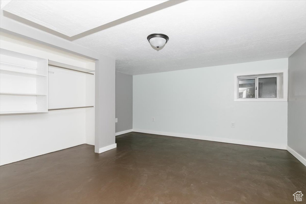 Below grade area featuring a textured ceiling and baseboards