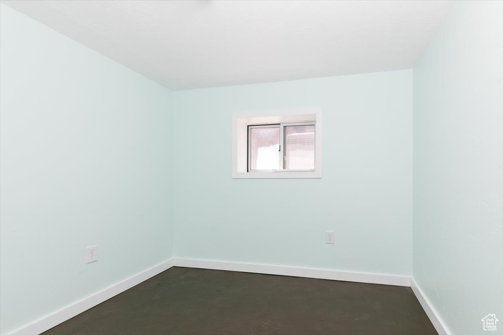 Unfurnished room with baseboards and concrete floors