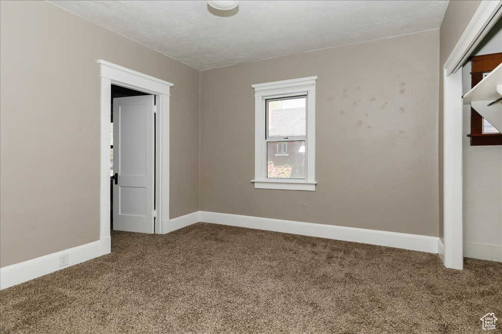 Empty room featuring carpet floors and baseboards