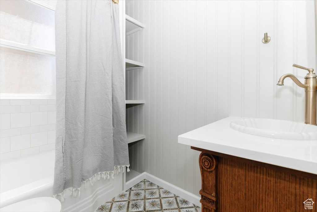 Full bathroom with vanity, baseboards, and shower / tub combo with curtain