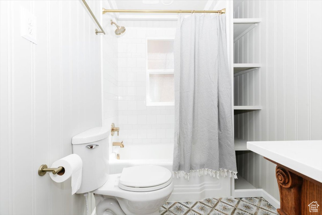 Full bathroom featuring toilet and shower / tub combo with curtain