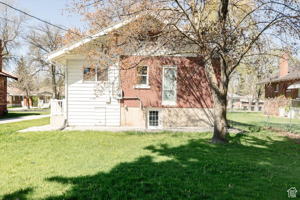 Back of house featuring fence and a yard
