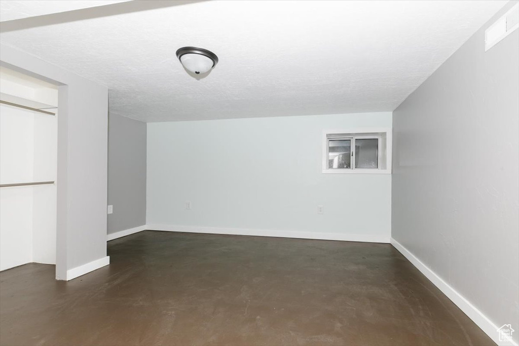 Basement with baseboards and visible vents