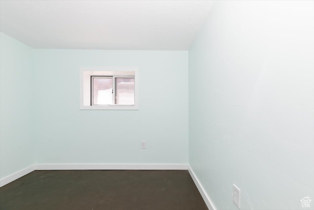 Spare room with concrete flooring and baseboards