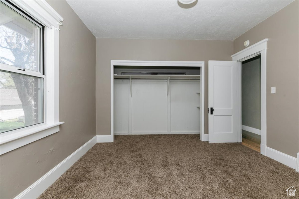Unfurnished bedroom with carpet floors, baseboards, and a closet