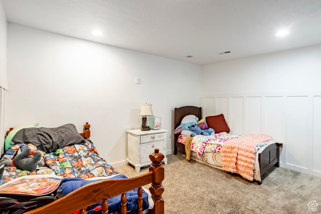 Carpeted bedroom featuring visible vents, a wainscoted wall, and recessed lighting