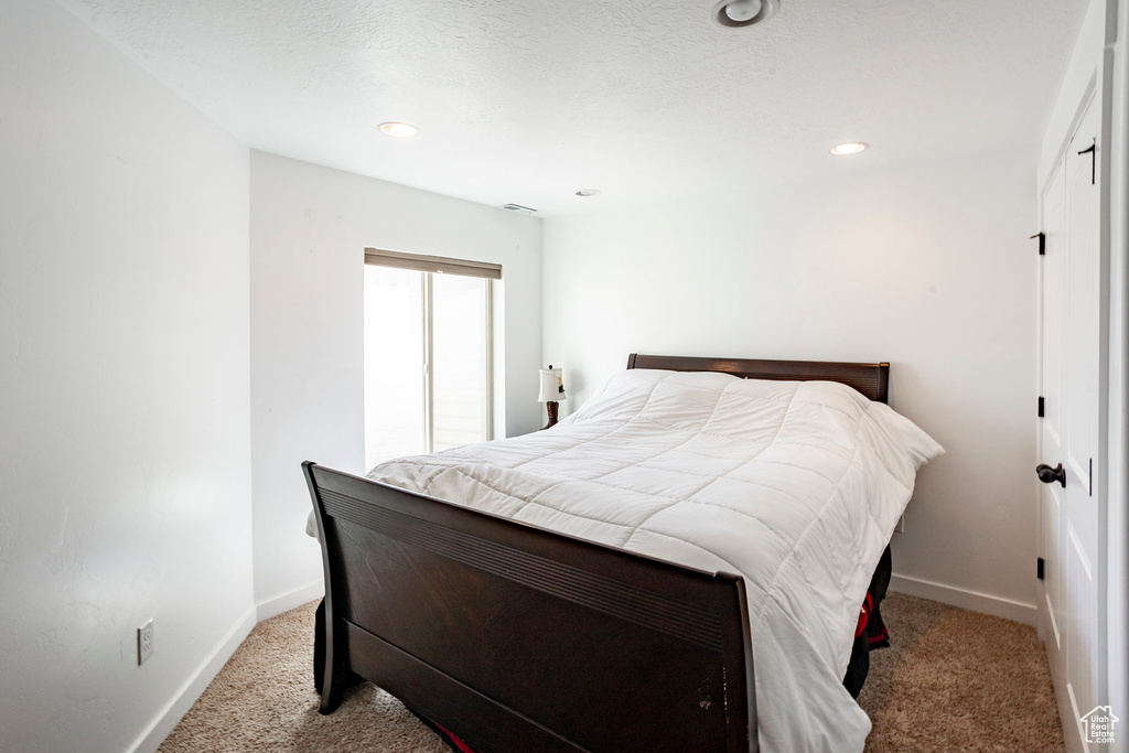 Carpeted bedroom with recessed lighting, visible vents, and baseboards