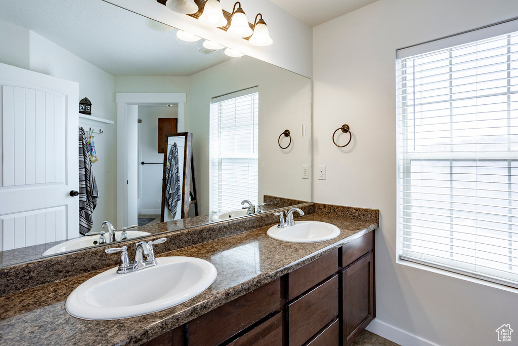 Bathroom with double vanity, a wealth of natural light, and a sink