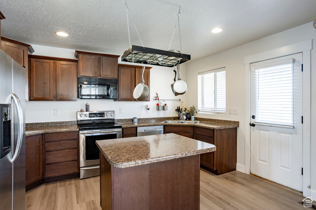Kitchen with a center island, light wood-style flooring, visible vents, and appliances with stainless steel finishes