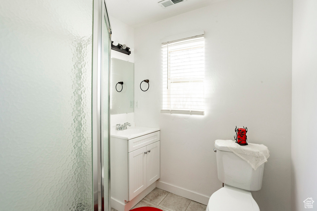 Bathroom featuring vanity, tile patterned floors, toilet, visible vents, and baseboards