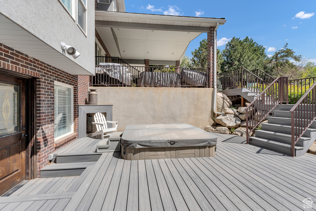 Deck with a covered hot tub and stairway
