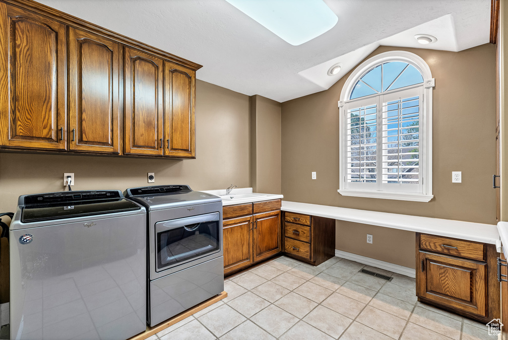 Laundry area featuring a sink, visible vents, independent washer and dryer, cabinet space, and light tile patterned floors