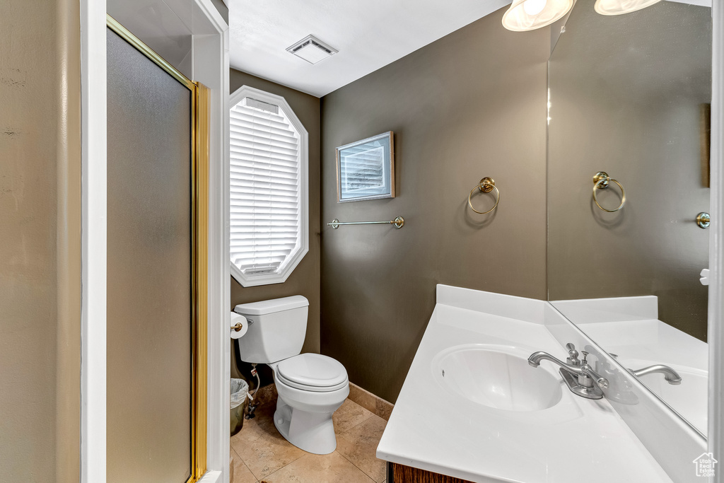Full bath with a shower stall, tile patterned floors, visible vents, toilet, and vanity