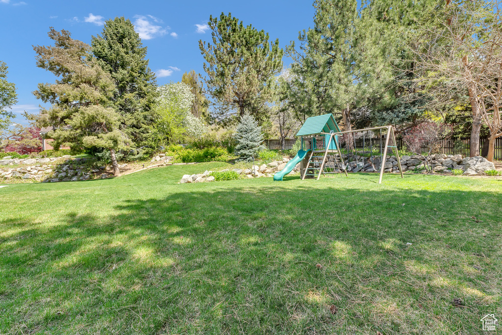 View of yard featuring fence and a playground