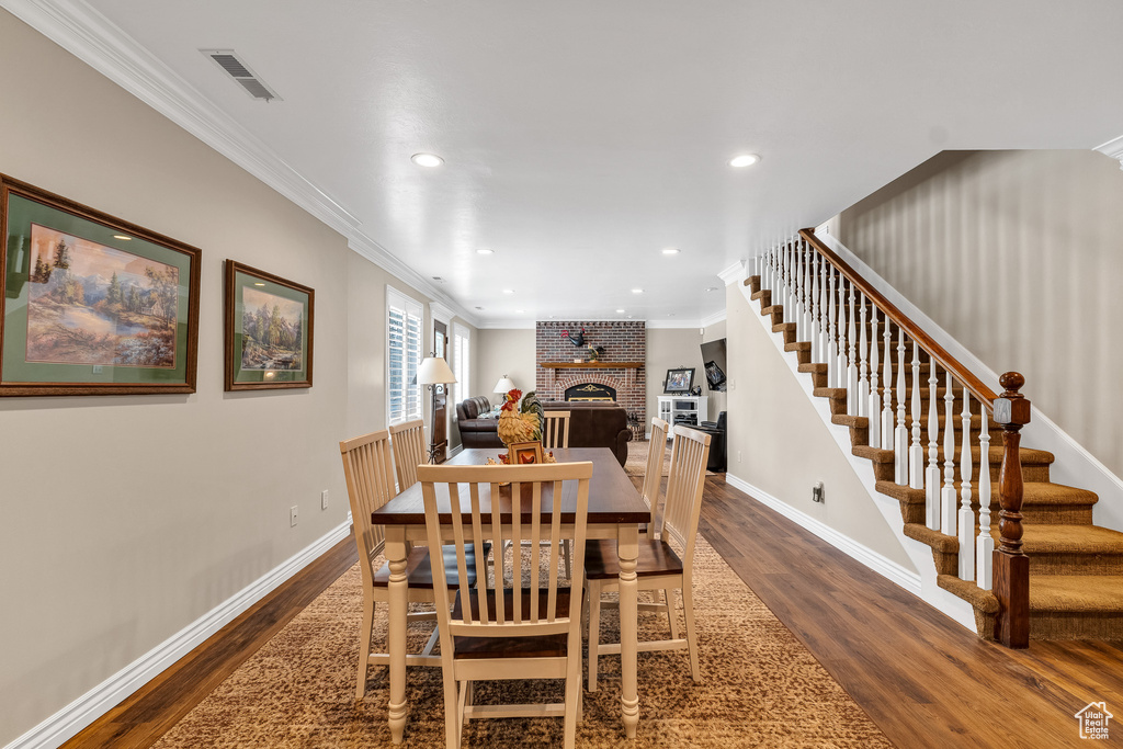 Dining space with stairway, dark wood-type flooring, and visible vents