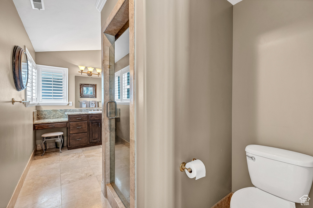 Full bathroom with a shower stall, vaulted ceiling, visible vents, toilet, and vanity