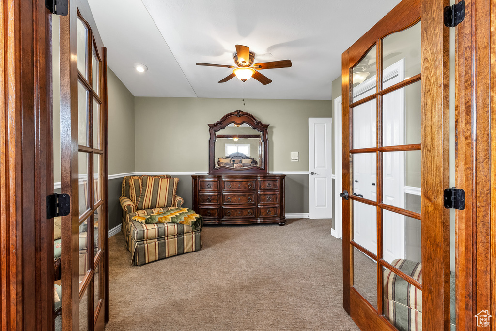Sitting room featuring carpet, baseboards, ceiling fan, and french doors
