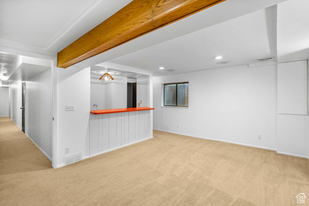 Carpeted spare room featuring recessed lighting, indoor bar, and baseboards
