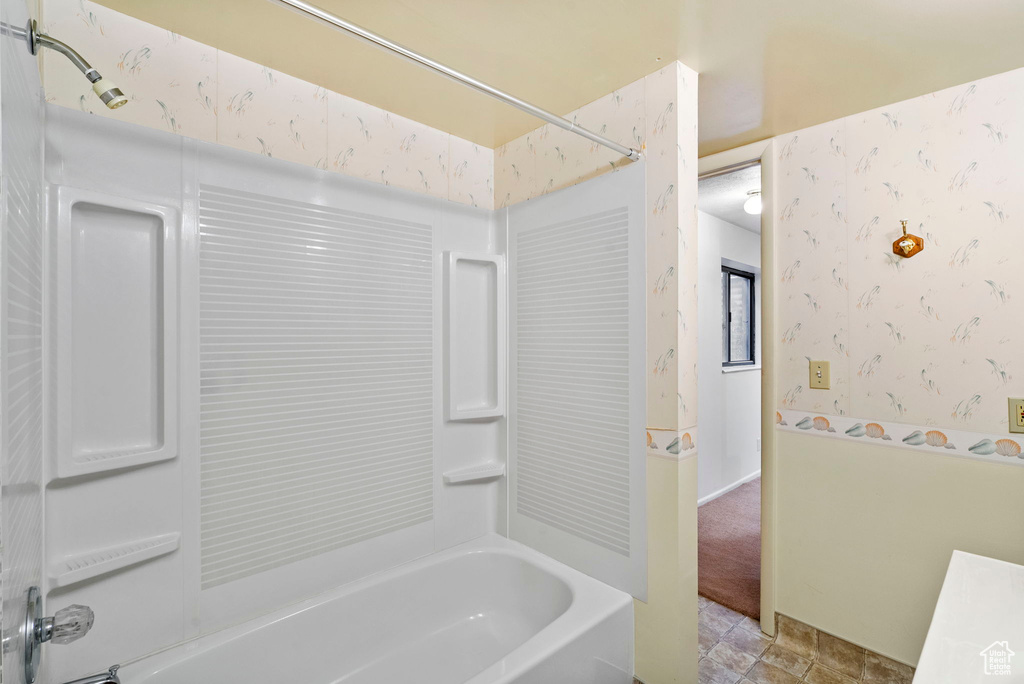 Full bath featuring wallpapered walls and bathing tub / shower combination