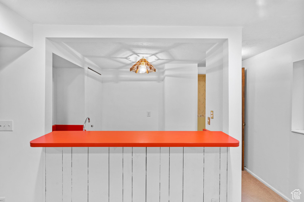Interior space with bar area, carpet floors, and baseboards