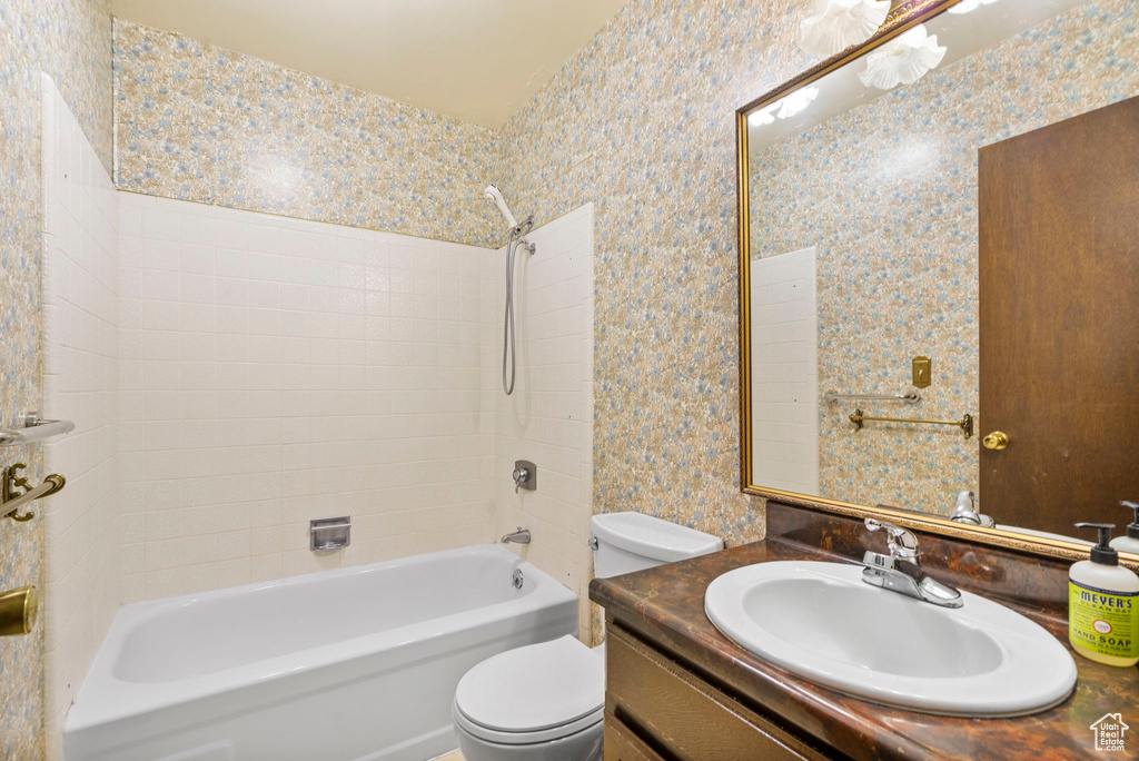 Bathroom with toilet, shower / tub combination, and vanity