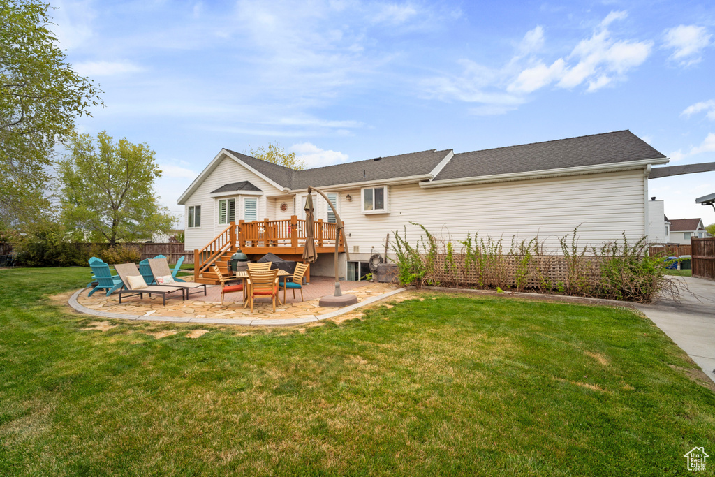 Rear view of property featuring a patio, a wooden deck, stairway, a yard, and fence