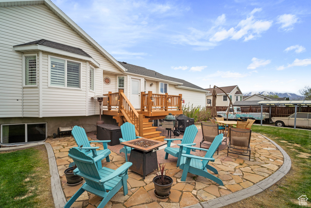 View of patio featuring a deck and a fire pit