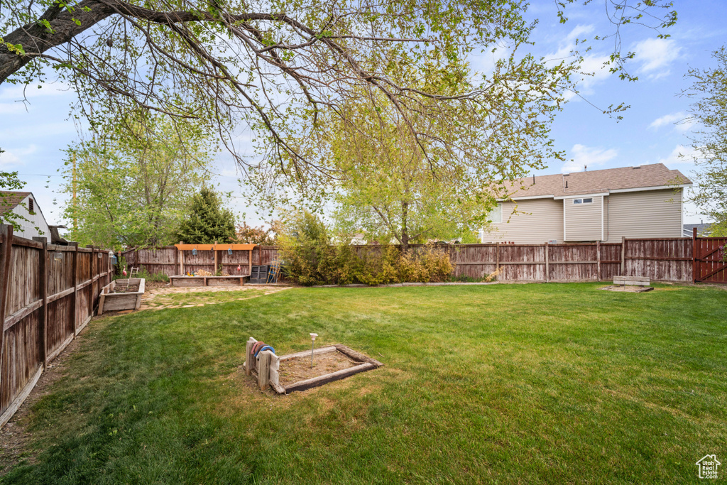 View of yard with a garden and a fenced backyard
