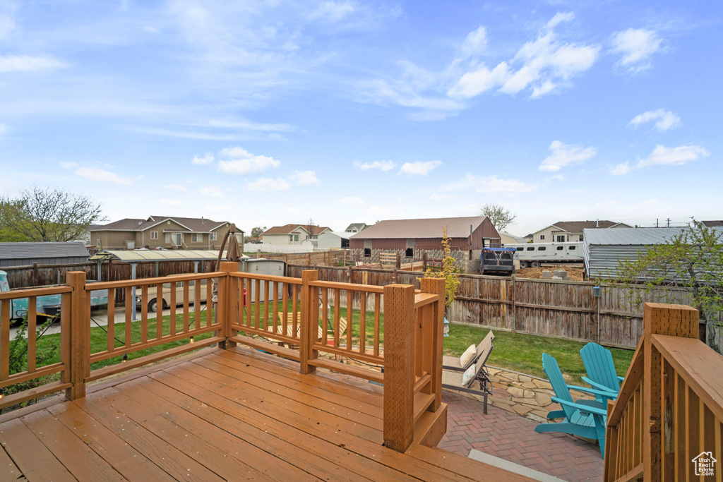 Deck featuring a lawn, a fenced backyard, a residential view, and a patio area