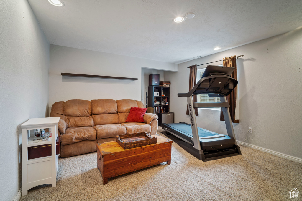 Carpeted living area featuring recessed lighting and baseboards
