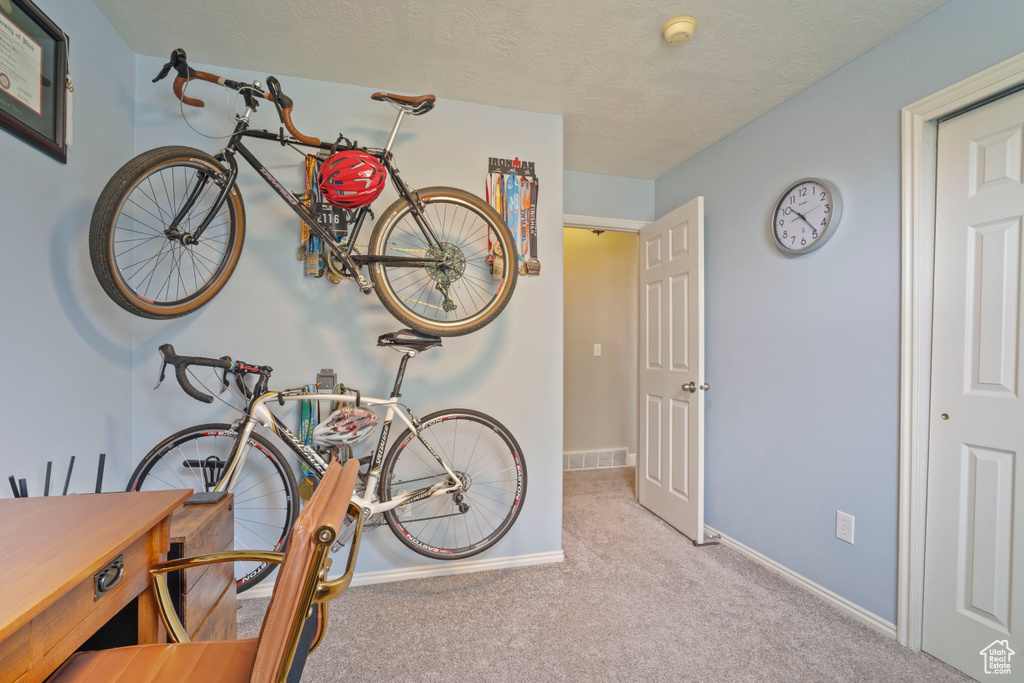 Interior space featuring a textured ceiling, visible vents, and baseboards